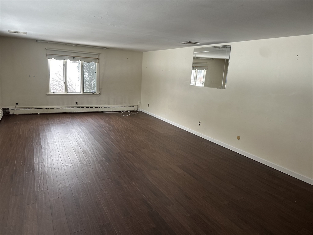 101 Hackensack Road Boston, MA 02467 - Photo 6 of 33 an empty room with wooden floor and windows