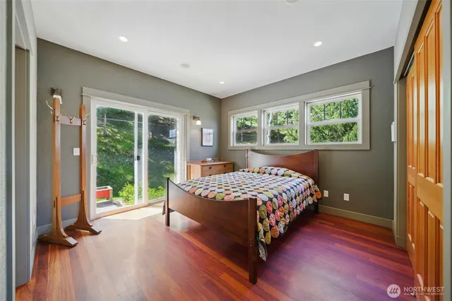 a bedroom with a bed and large windows