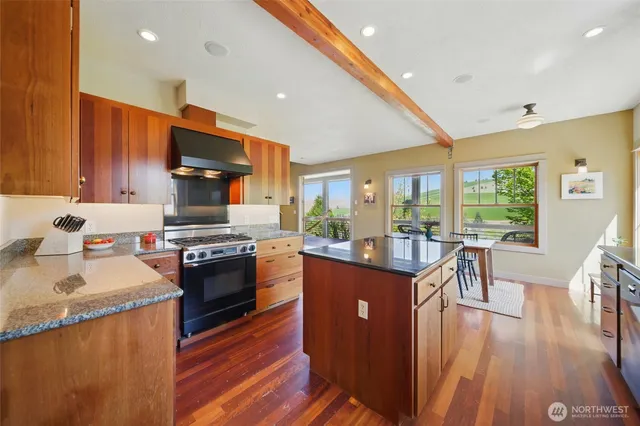 a kitchen with stainless steel appliances granite countertop sink stove top oven and cabinets