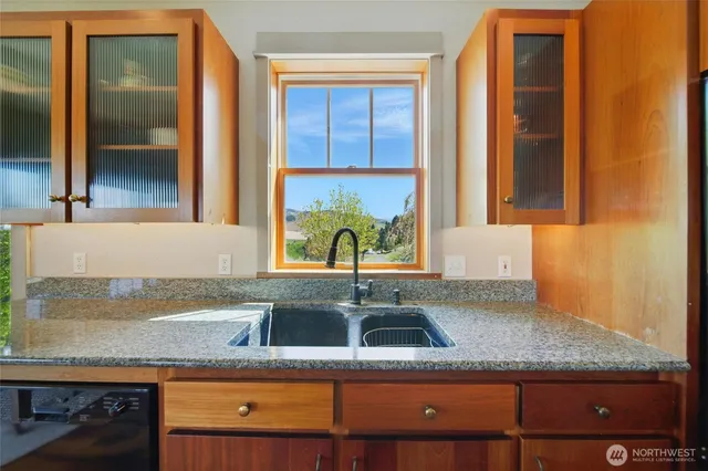 a kitchen with sink a window and cabinets