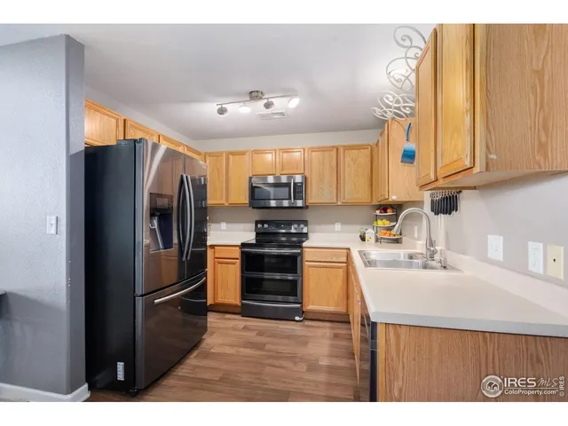 a kitchen with stainless steel appliances granite countertop a refrigerator sink and stove