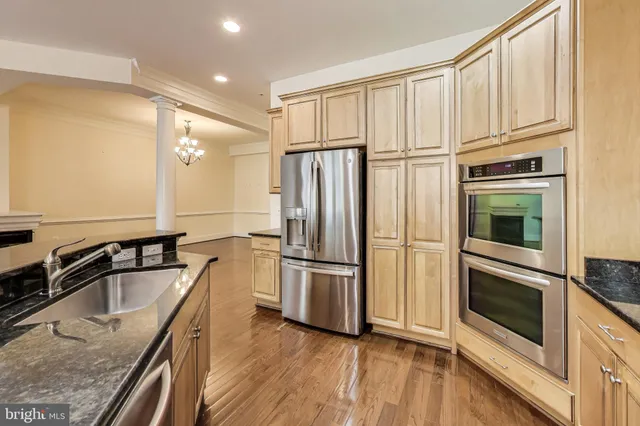 a kitchen with granite countertop a sink cabinets and stainless steel appliances