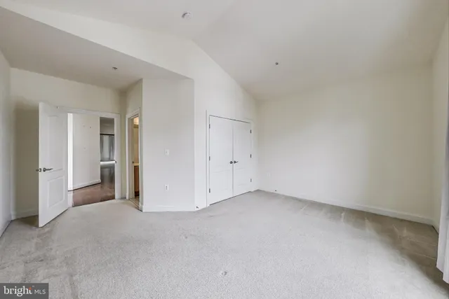 a view of an empty room with stairs and a ceiling fan