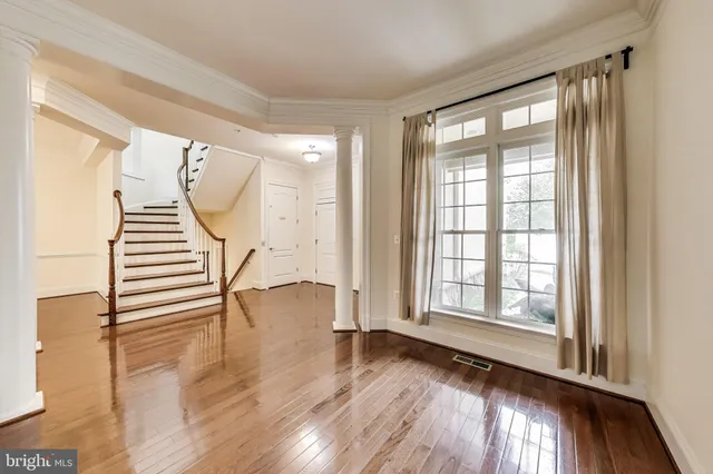 a view of empty room with wooden floor