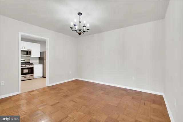 wooden floor in an empty room with a chandelier