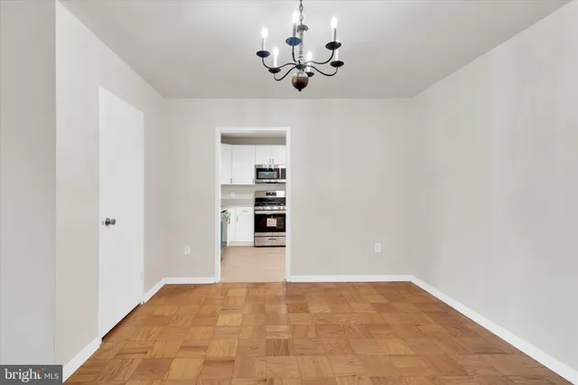 a view of an empty room with a chandelier fan