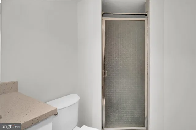 a white toilet sitting next to a shower