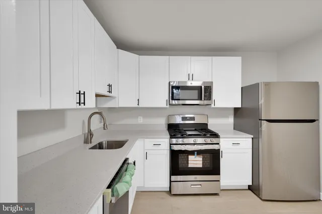a kitchen with white cabinets and stainless steel appliances