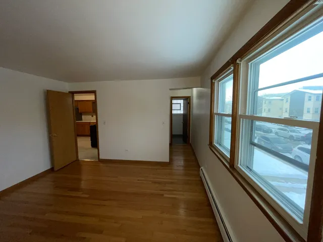 a view of hallway with wooden floor and windows