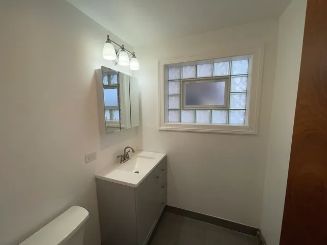 a bathroom with a sink toilet and mirror