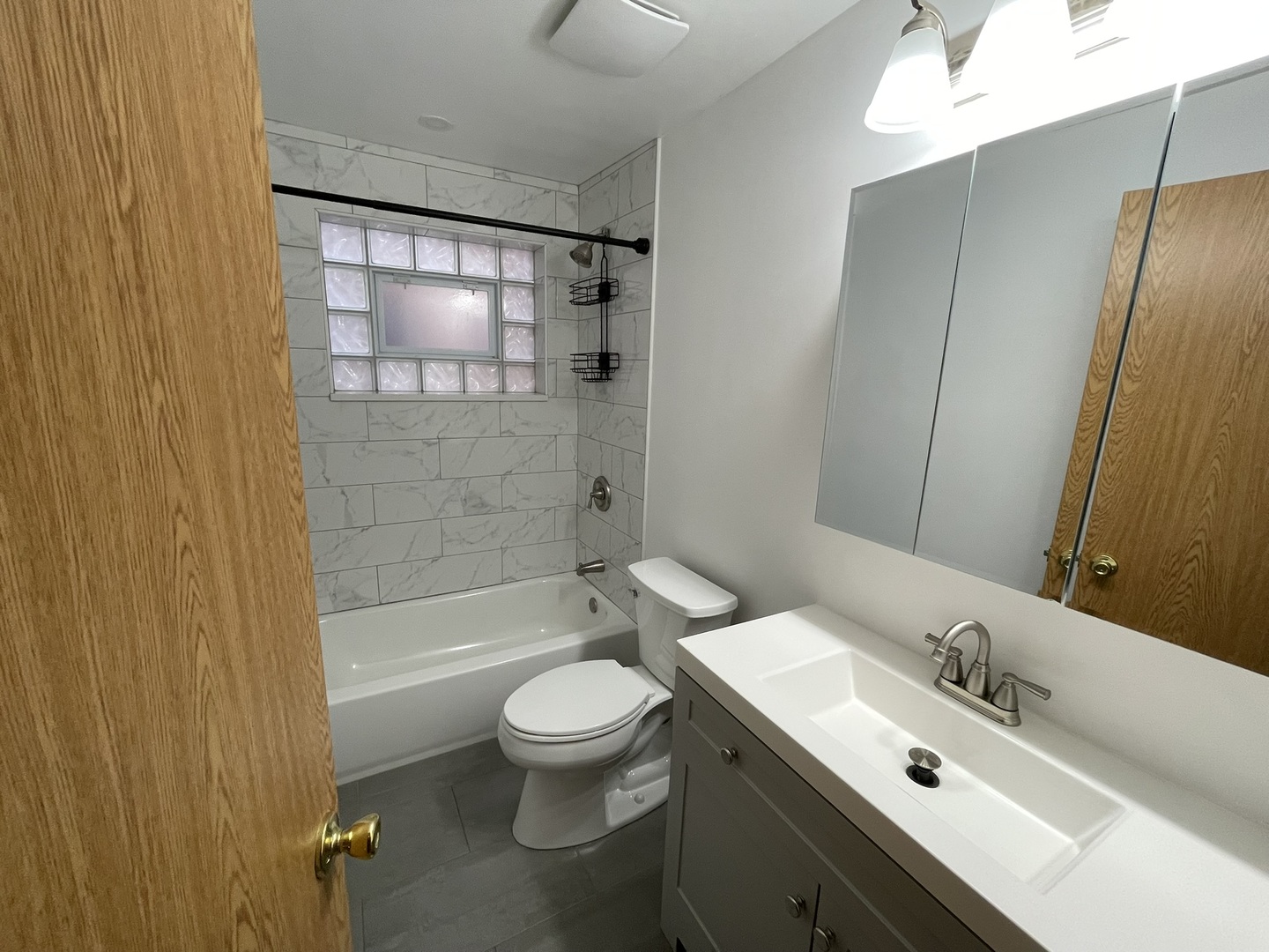 8511 West Gregory Street, Unit 2N Chicago, IL 60656 - Photo 8 of 15 a bathroom with a bathtub shower sink mirror vanity and toilet
