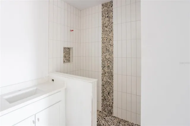 a bathroom with a granite countertop sink and a bathtub