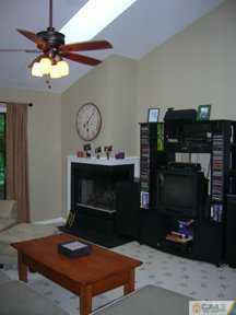 2810 Ridgefield Court Helmetta, NJ 08828 - Photo 5 of 8 a living room with furniture a flat screen tv and a fireplace