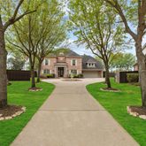 a front view of a house with a yard and fountain