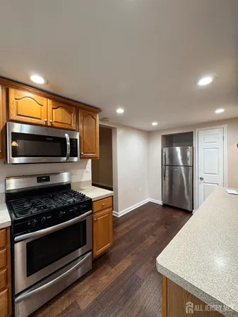 a kitchen with stainless steel appliances granite countertop a stove a sink and a microwave