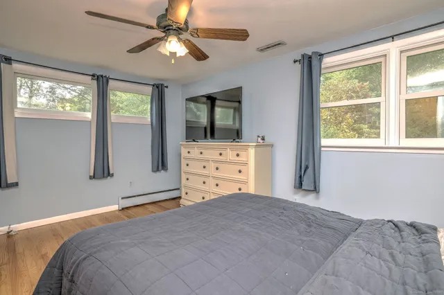 a bedroom with a bed dresser and a window