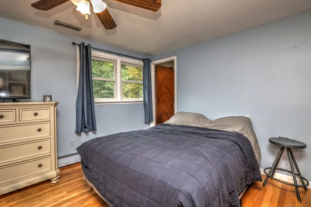 a bedroom with a bed and a flat tv screen on dresser