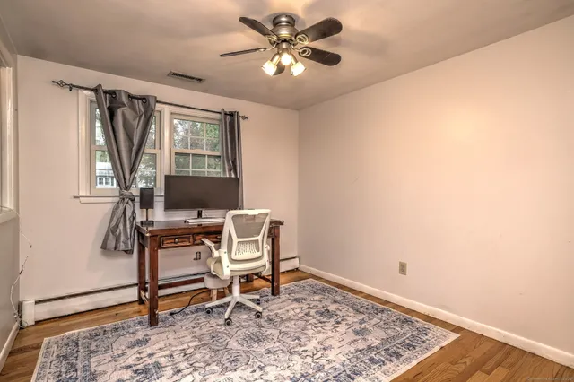 a workspace with wooden floor and a window