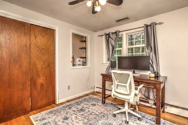 a workspace with wooden floor and a chandelier fan