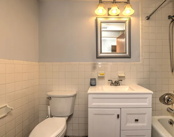 a bathroom with a toilet sink vanity and mirror