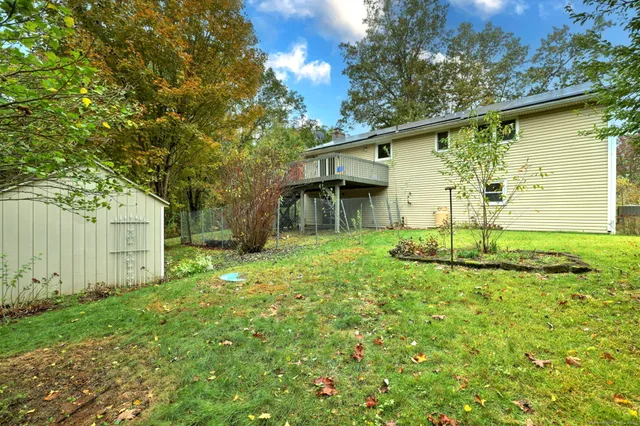 a white house that has tree in front of it