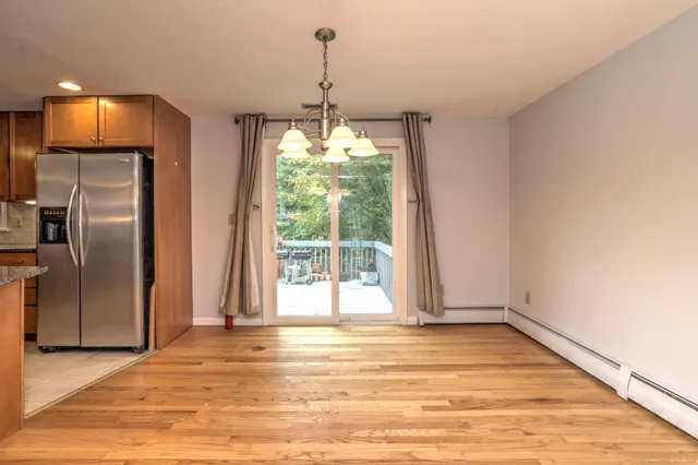 a view of a livingroom with a chandelier and wooden floor