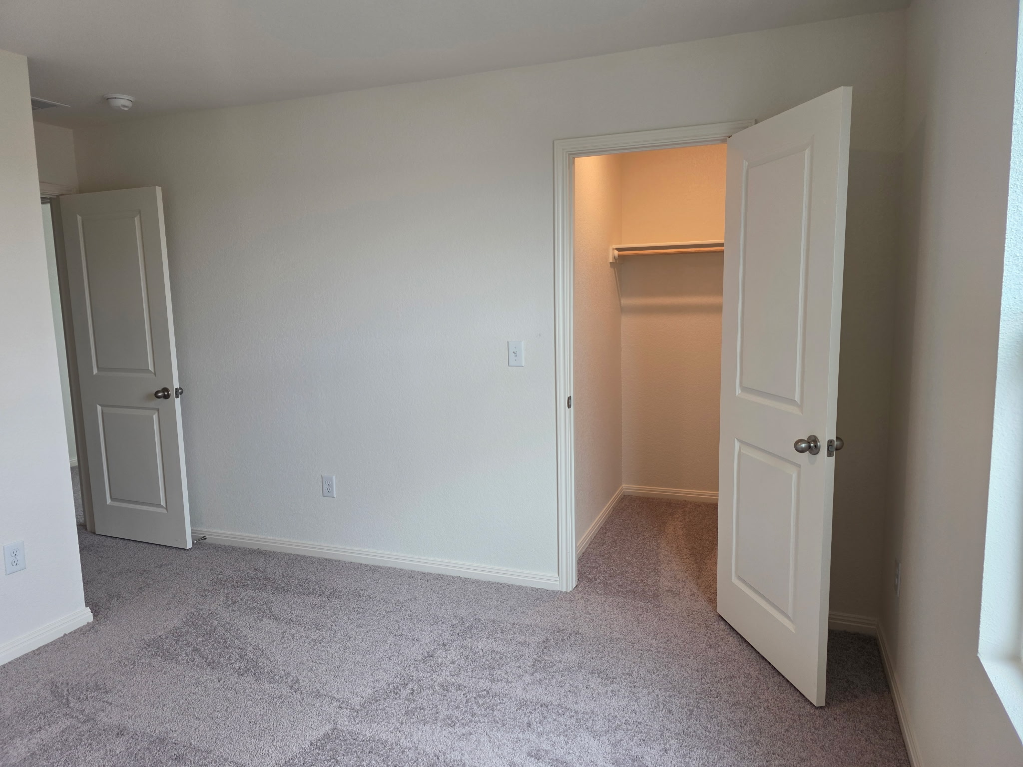 353 Enforcer Loop Jarrell, TX 76537 - Photo 14 of 21 Unfurnished bedroom with carpet, a walk in closet, baseboards, and a closet