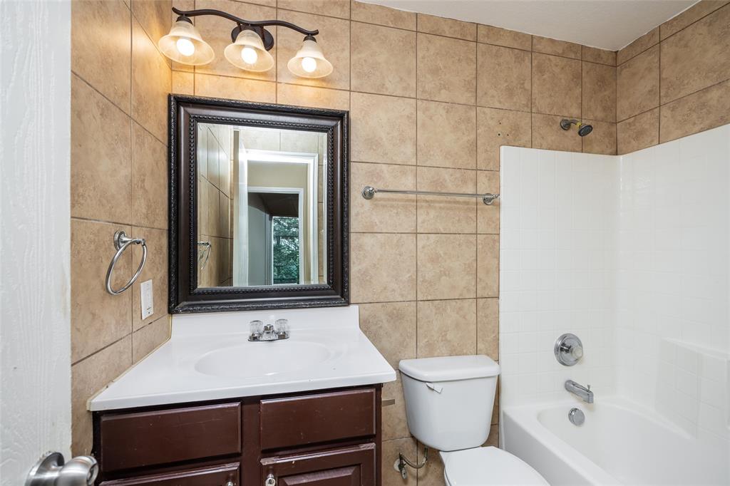 112 Bushel Lane Dallas, TX 75241 - Photo 13 of 16 a bathroom with a sink a toilet and mirror