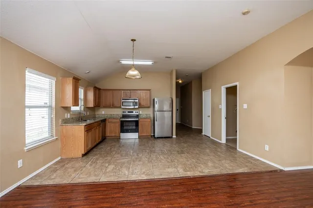 a open kitchen with stainless steel appliances granite countertop a stove refrigerator and cabinets
