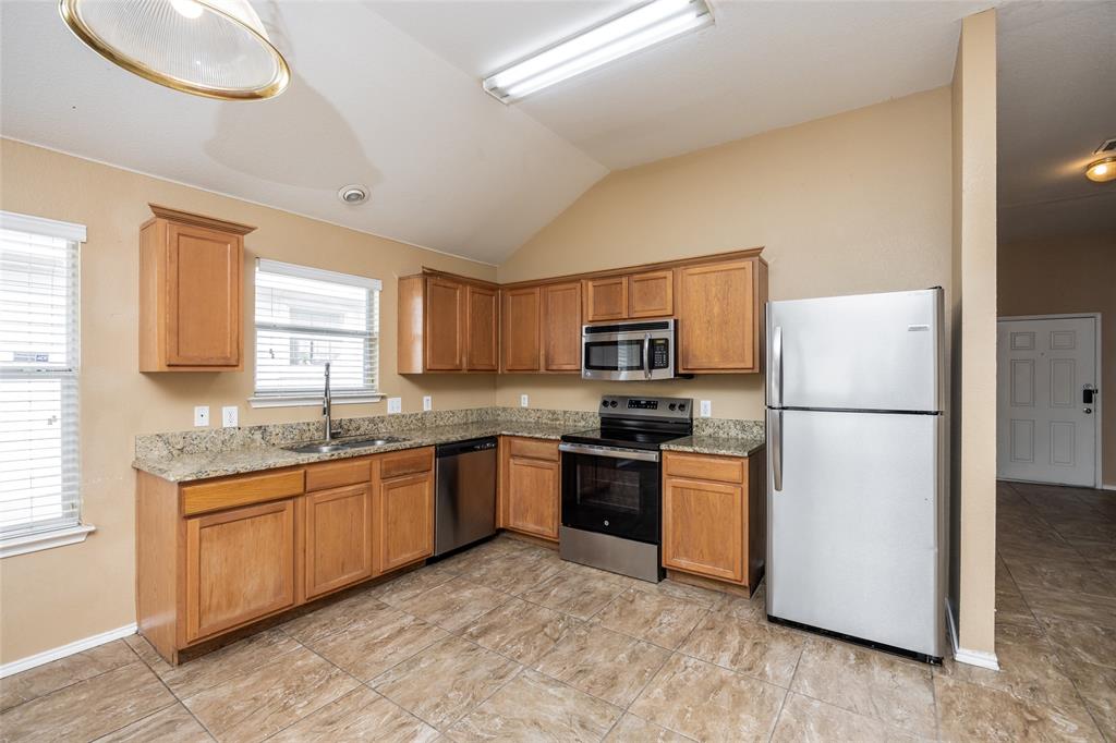 112 Bushel Lane Dallas, TX 75241 - Photo 5 of 16 a kitchen with stainless steel appliances granite countertop a refrigerator a stove a sink and a microwave
