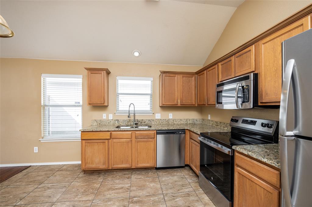 112 Bushel Lane Dallas, TX 75241 - Photo 6 of 16 a kitchen with stainless steel appliances granite countertop a sink stove and refrigerator