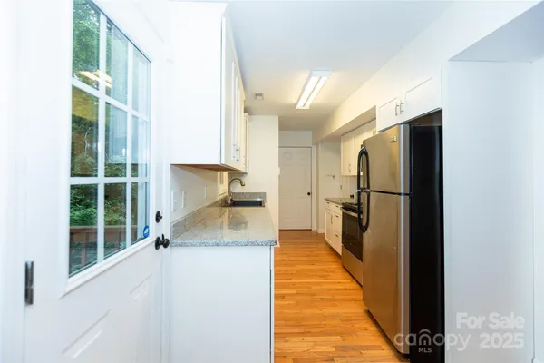 a view of a kitchen with wooden floor and a refrigerator