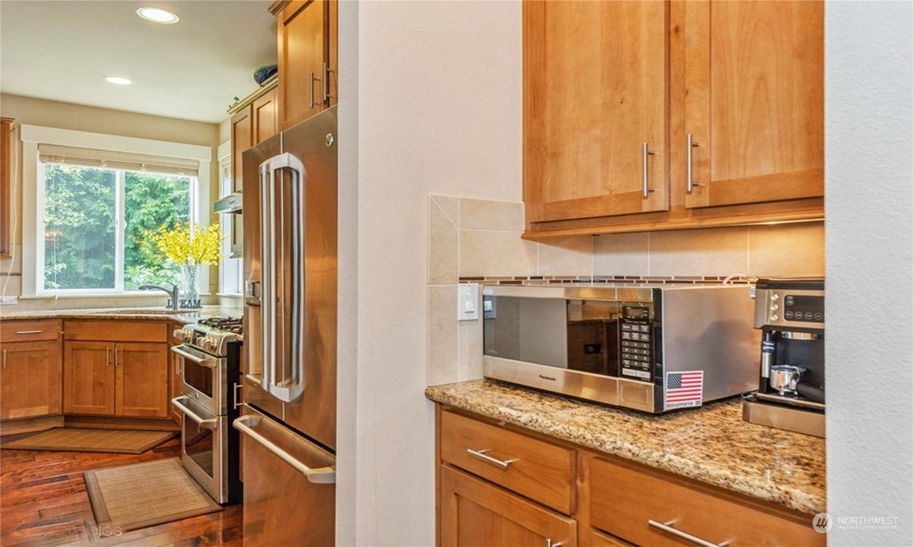 6219 Southeast 2nd Street Renton, WA 98059 - Photo 13 of 40 a kitchen with stainless steel appliances granite countertop a refrigerator a stove and white cabinets with wooden floor