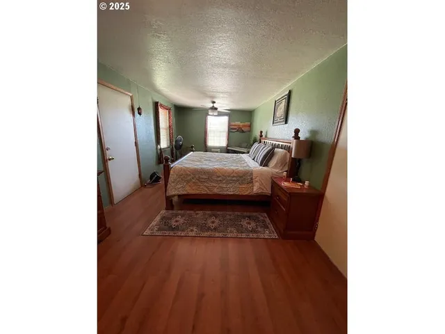 a spacious bedroom with a bed and a lamp