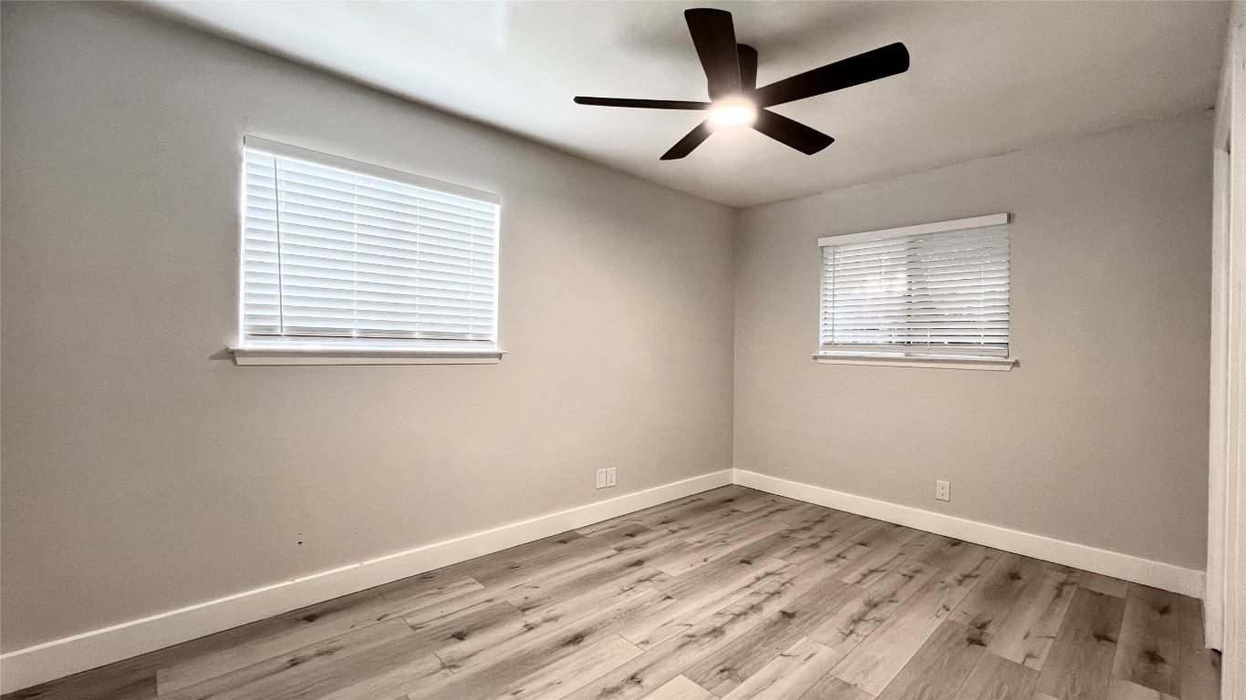 11103 Renel Drive, Unit A Austin, TX 78758 - Photo 5 of 7 a view of empty room with wooden floor and fan