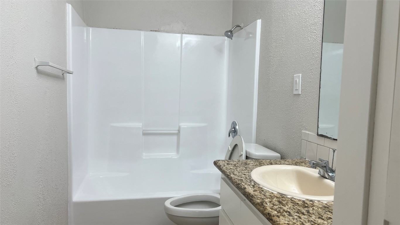 11103 Renel Drive, Unit A Austin, TX 78758 - Photo 6 of 7 a bathroom with a granite countertop sink a toilet and shower
