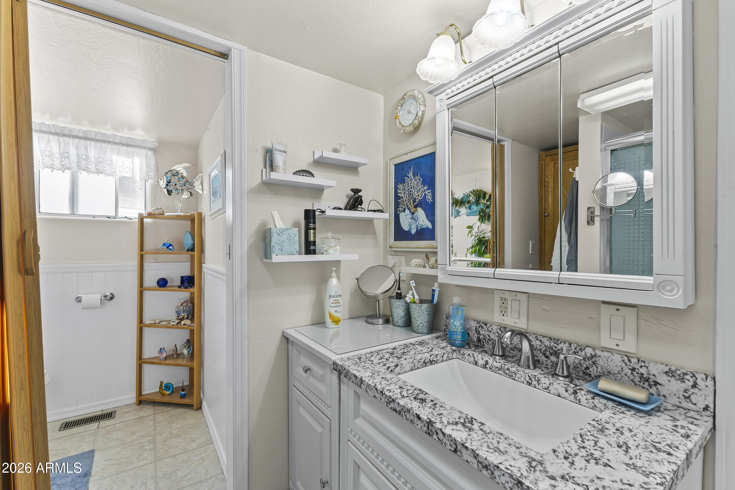 17200 West Bell Road, Unit 548 Surprise, AZ 85374 - Photo 17 of 19 a bathroom with a granite countertop sink mirror and shower