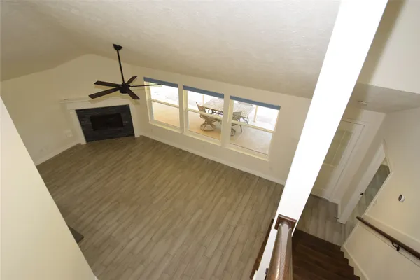 a view of empty room with wooden floor and ceiling fan