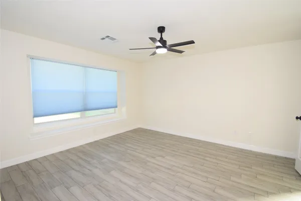 a view of an empty room with wooden floor
