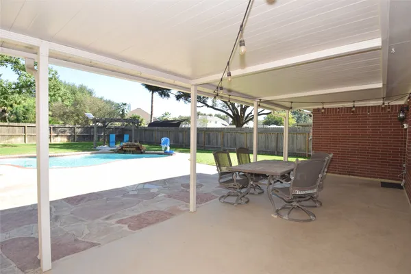 a view of patio with table and chairs under an umbrella