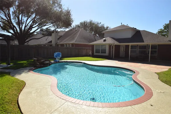 a view of a house with swimming pool and yard with furniture