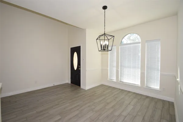 a view of empty room with window and wooden floor
