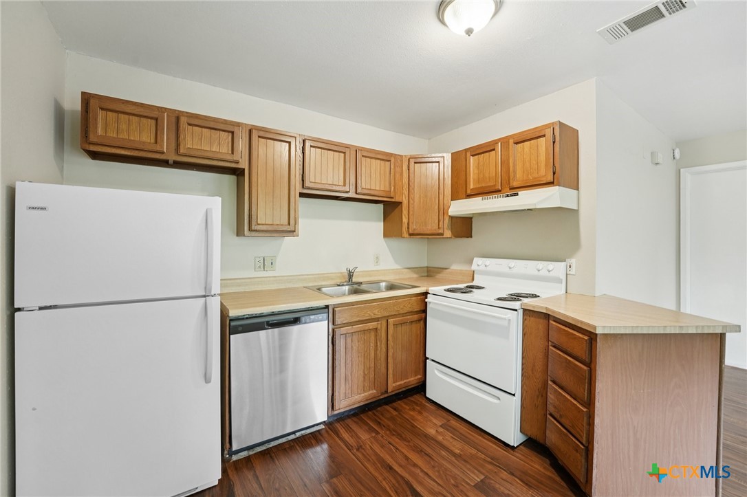 1634 Post Road, Unit 4 San Marcos, TX 78666 - Photo 10 of 11 a kitchen with a white cabinets and white appliances