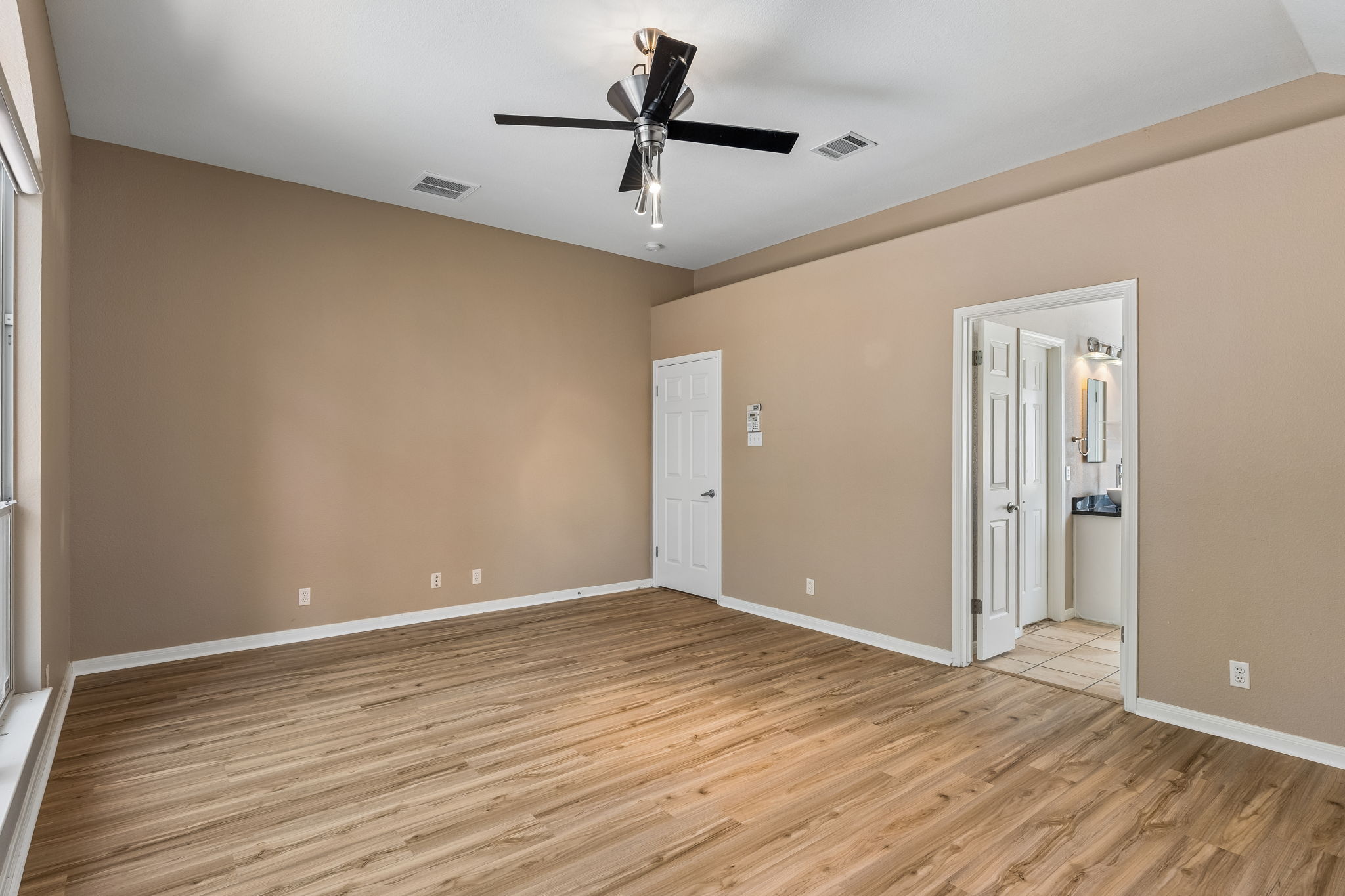 15814 Rustic Lane Austin, TX 78717 - Photo 22 of 29 Rich wood-inspired flooring pairs beautifully with high ceilings in this tranquil bedroom suite.