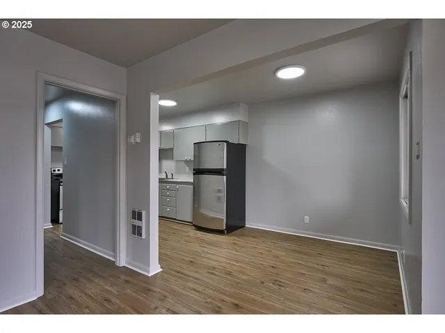 a view of empty room with wooden floor