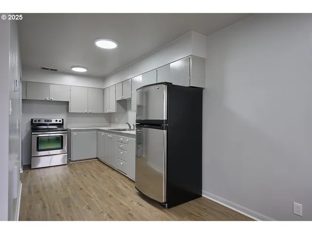 a kitchen with a refrigerator and a stove top oven