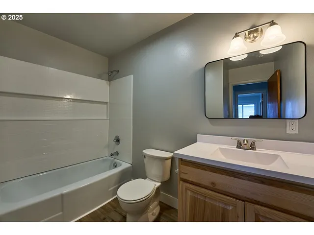 a bathroom with a sink a toilet a mirror and shower