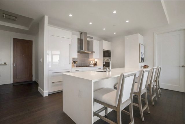 a kitchen with kitchen island wooden cabinets and refrigerator