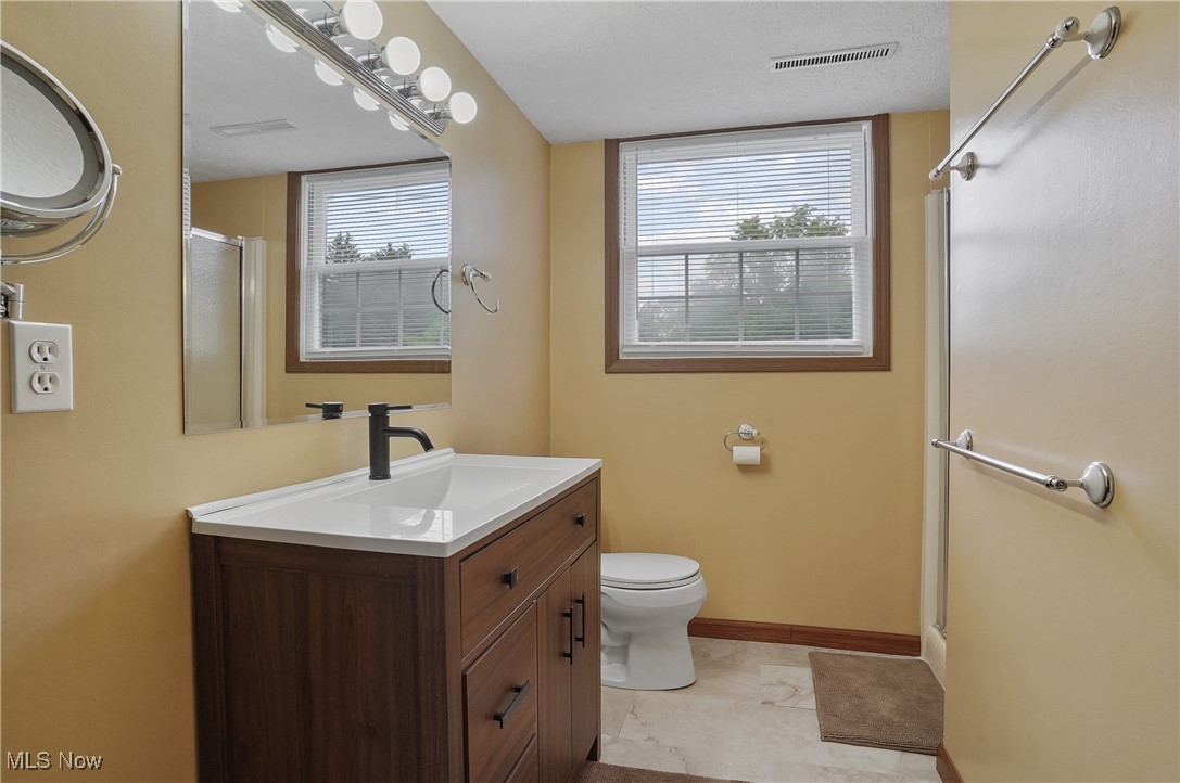 3262 Wright Road Northwest Uniontown, OH 44685 - Photo 32 of 37 Full bathroom with a shower with door, vanity, and marble finish floors