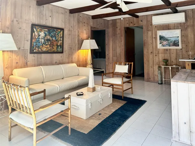 a living room with furniture and a painting on the wall